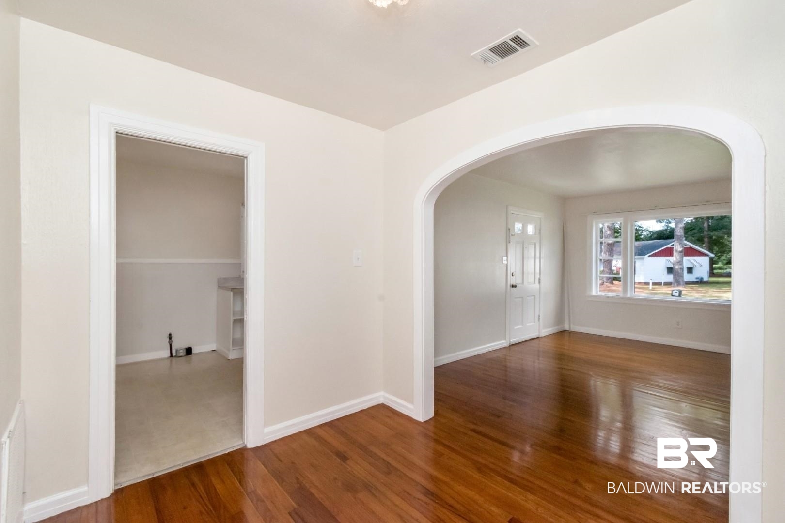 1477 Fairfield Street Mobile, AL 36606 - Photo 13 of 34 Spare room featuring arched walkways and dark wood finished floors