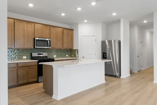 a kitchen with kitchen island a white cabinets and refrigerator