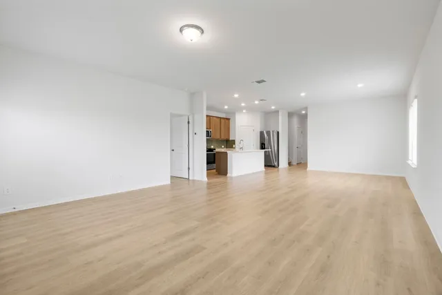 a view of kitchen with center island wooden floor stainless steel appliances and windows