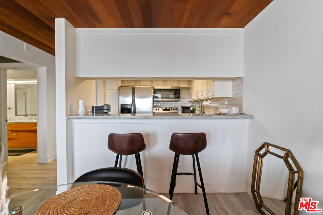 6209 Pacific Avenue, Unit 103 Playa del Rey, CA 90293 - Photo 16 of 40 a kitchen with stainless steel appliances granite countertop a sink a stove a dining table and chairs