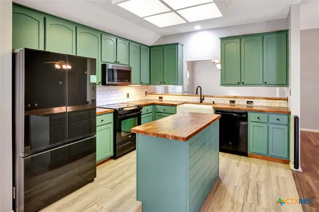 a kitchen with stainless steel appliances granite countertop a refrigerator a sink and a stove