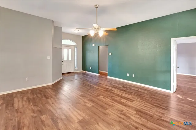 a view of a livingroom with a ceiling fan and wooden floor