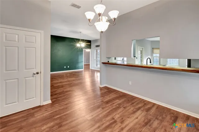 a view of a kitchen with wooden floor and a chandelier