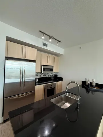 a kitchen with a refrigerator sink and stove