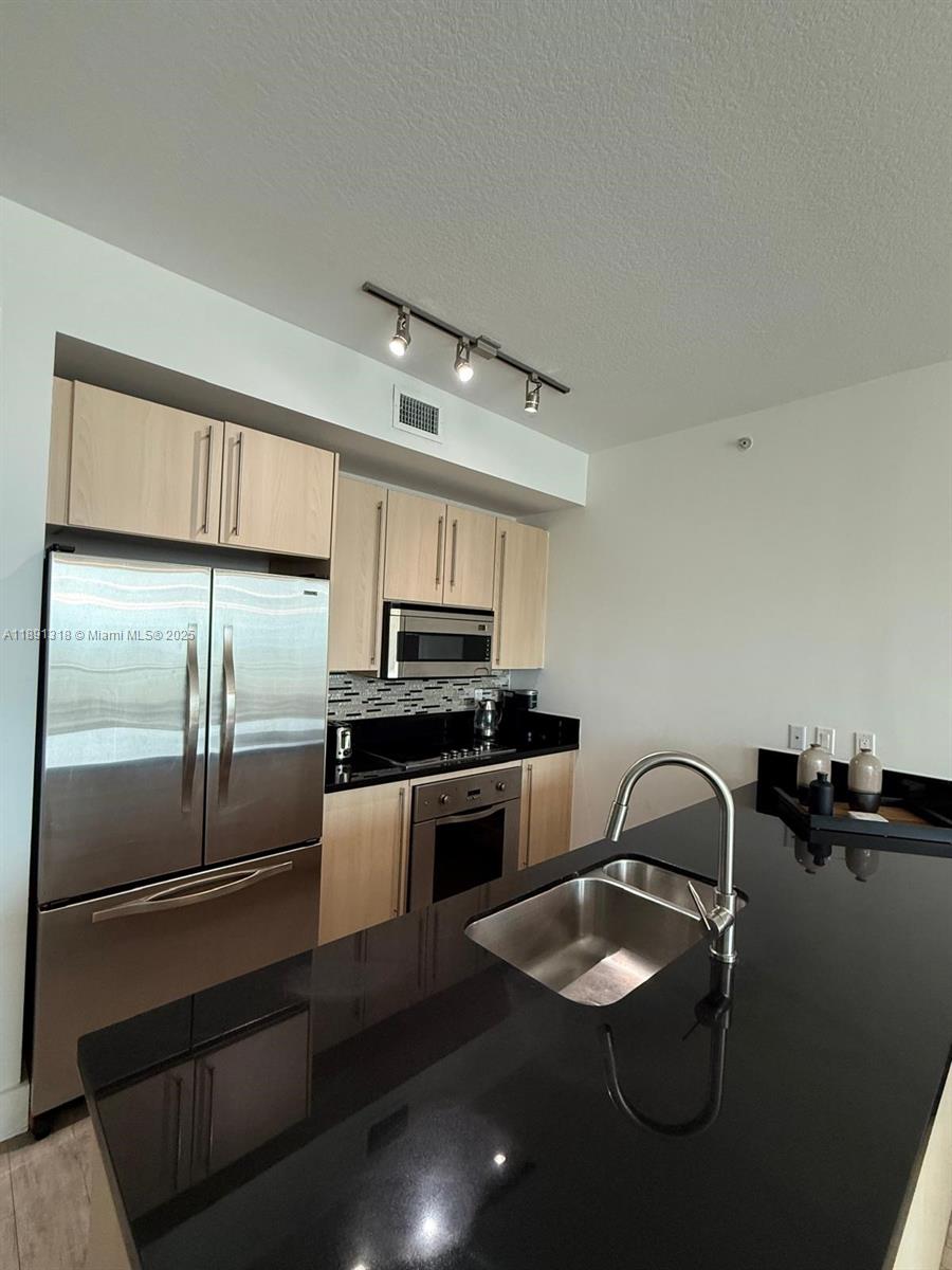 1111 Southwest 1st Avenue, Unit UPH4017 Miami, FL 33130 - Photo 4 of 14 a kitchen with a refrigerator sink and stove