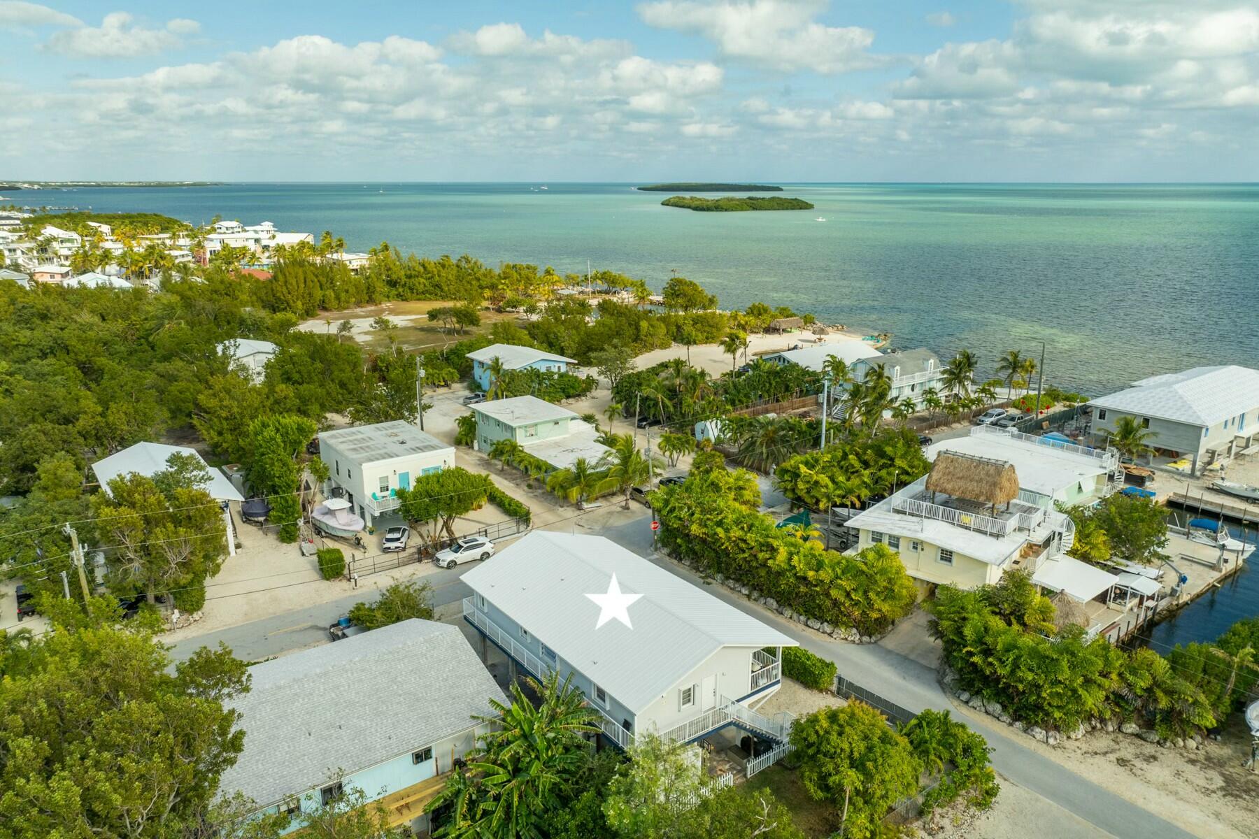 an aerial view of ocean with residential house with outdoor space