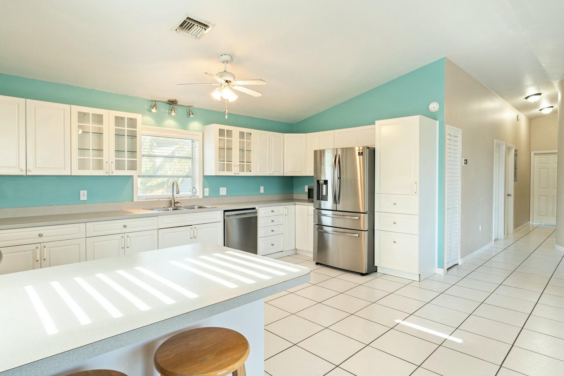 1010 Snapper Lane Key Largo, FL 33037 - Photo 7 of 26 a kitchen with a refrigerator a sink dishwasher with a dining table and chairs