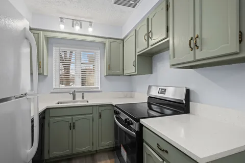 a kitchen with stainless steel appliances a sink a stove and cabinets