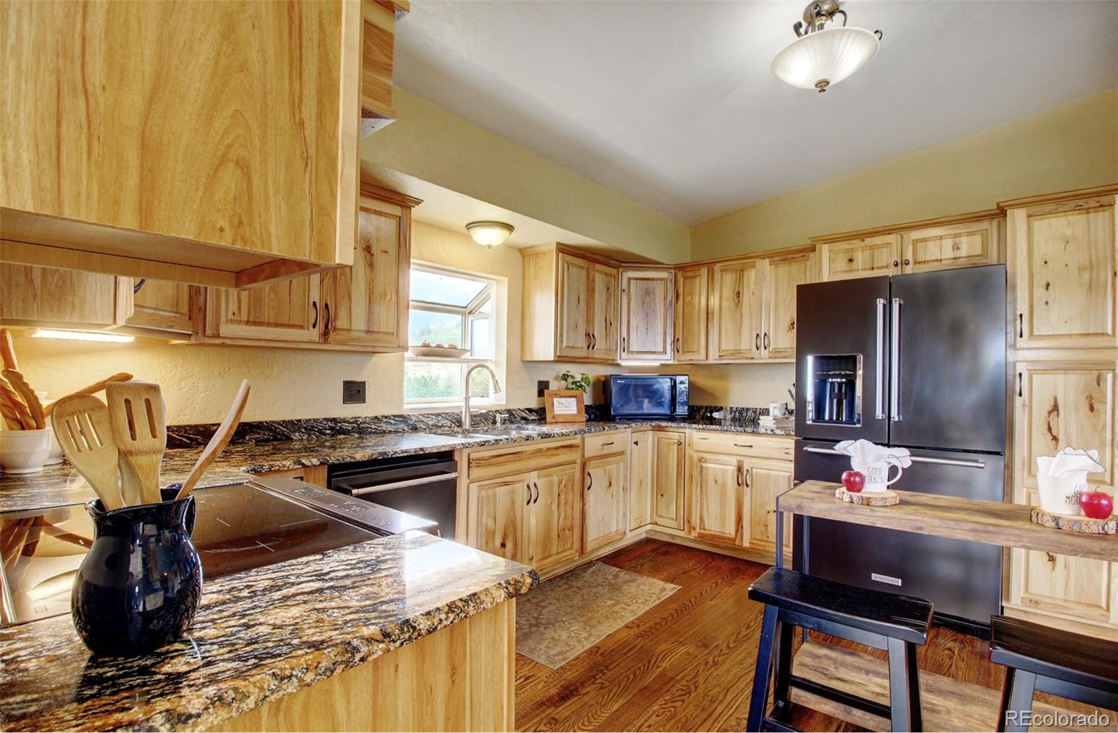4345 Evans Road Monument, CO 80132 - Photo 16 of 40 a kitchen with a refrigerator and a stove top oven