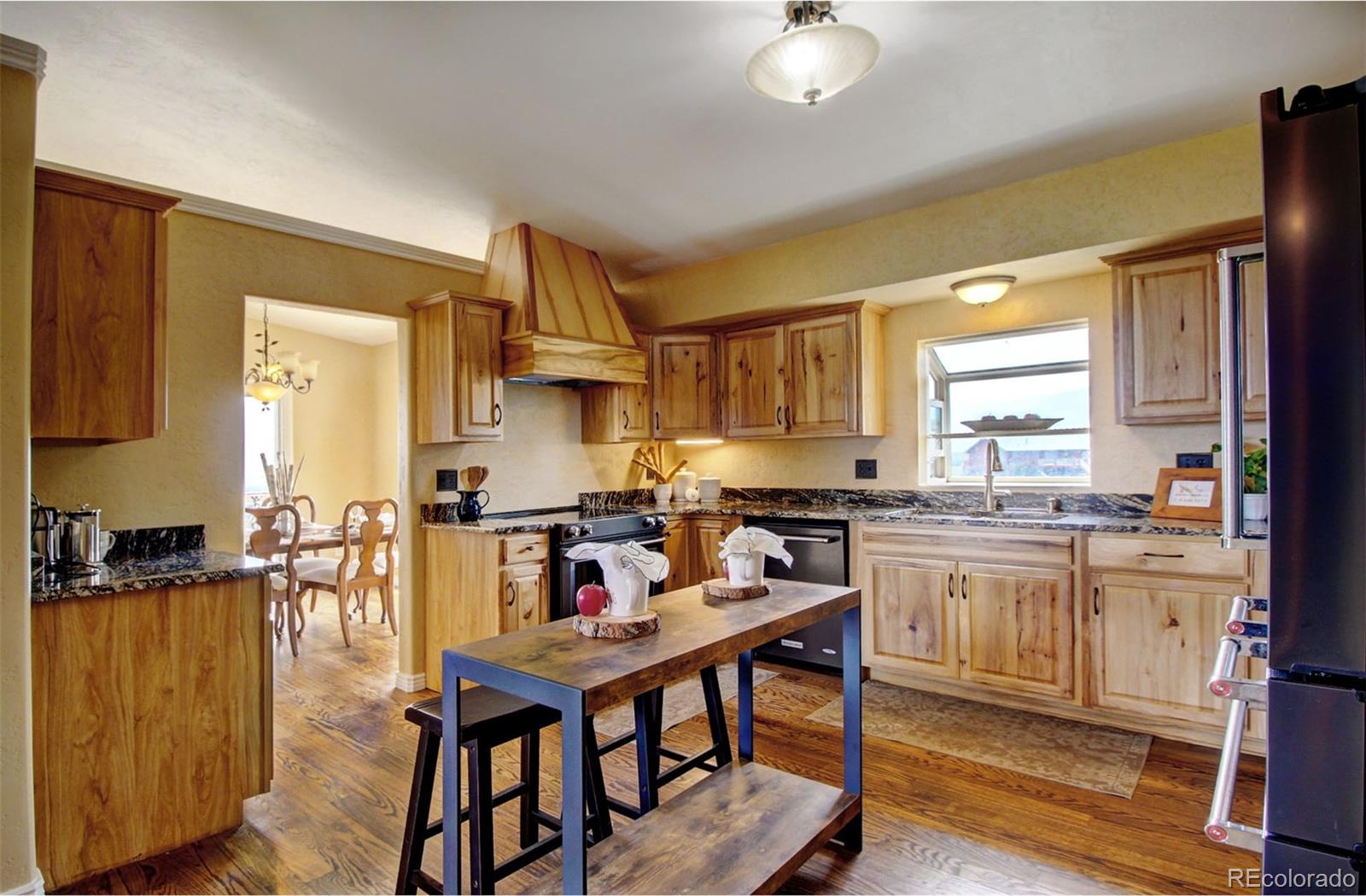 4345 Evans Road Monument, CO 80132 - Photo 17 of 40 a kitchen with a table chairs stove and cabinets