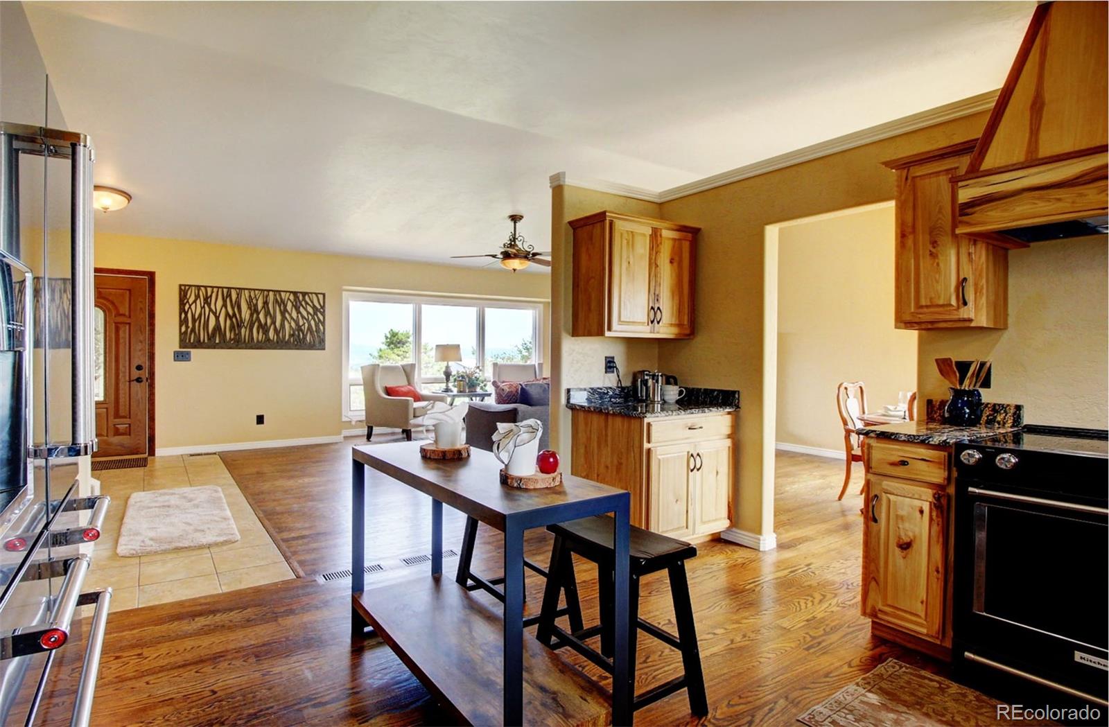 4345 Evans Road Monument, CO 80132 - Photo 18 of 40 a kitchen with a table chairs refrigerator and cabinets