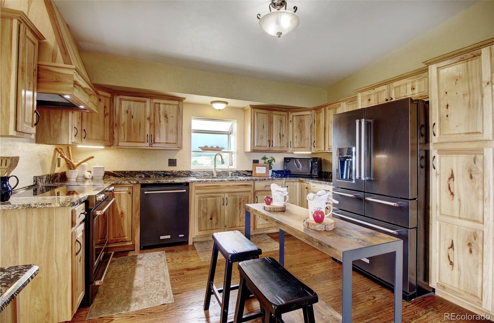 4345 Evans Road Monument, CO 80132 - Photo 19 of 40 a kitchen with a refrigerator stove top oven and sink