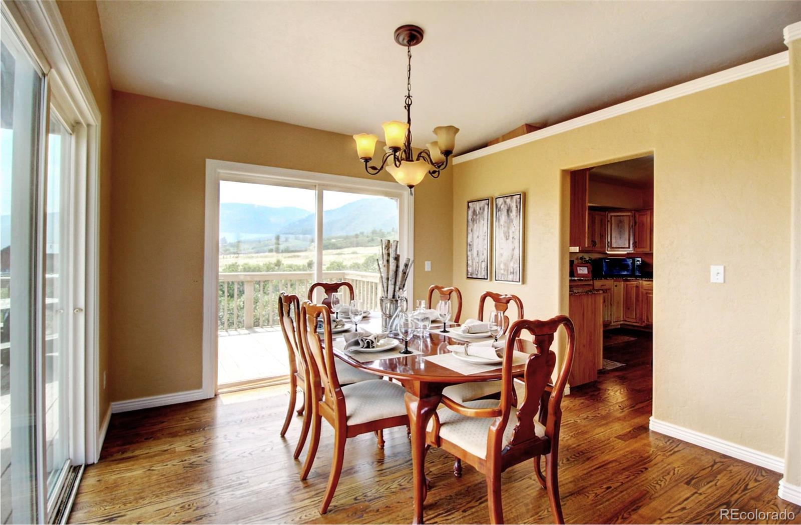 4345 Evans Road Monument, CO 80132 - Photo 20 of 40 a dining room with furniture window wooden floor and a chandelier