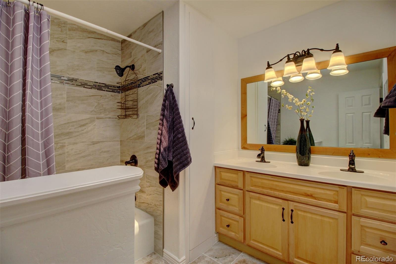 4345 Evans Road Monument, CO 80132 - Photo 22 of 40 a bathroom with a sink a mirror and a shower