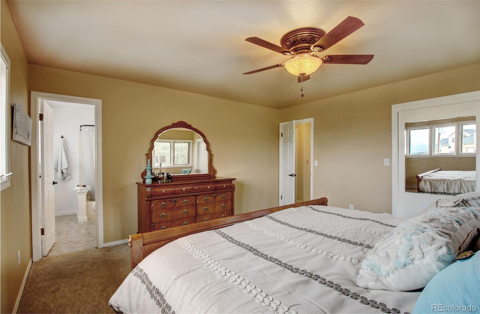 4345 Evans Road Monument, CO 80132 - Photo 26 of 40 a bedroom with a bed and dresser with mirror
