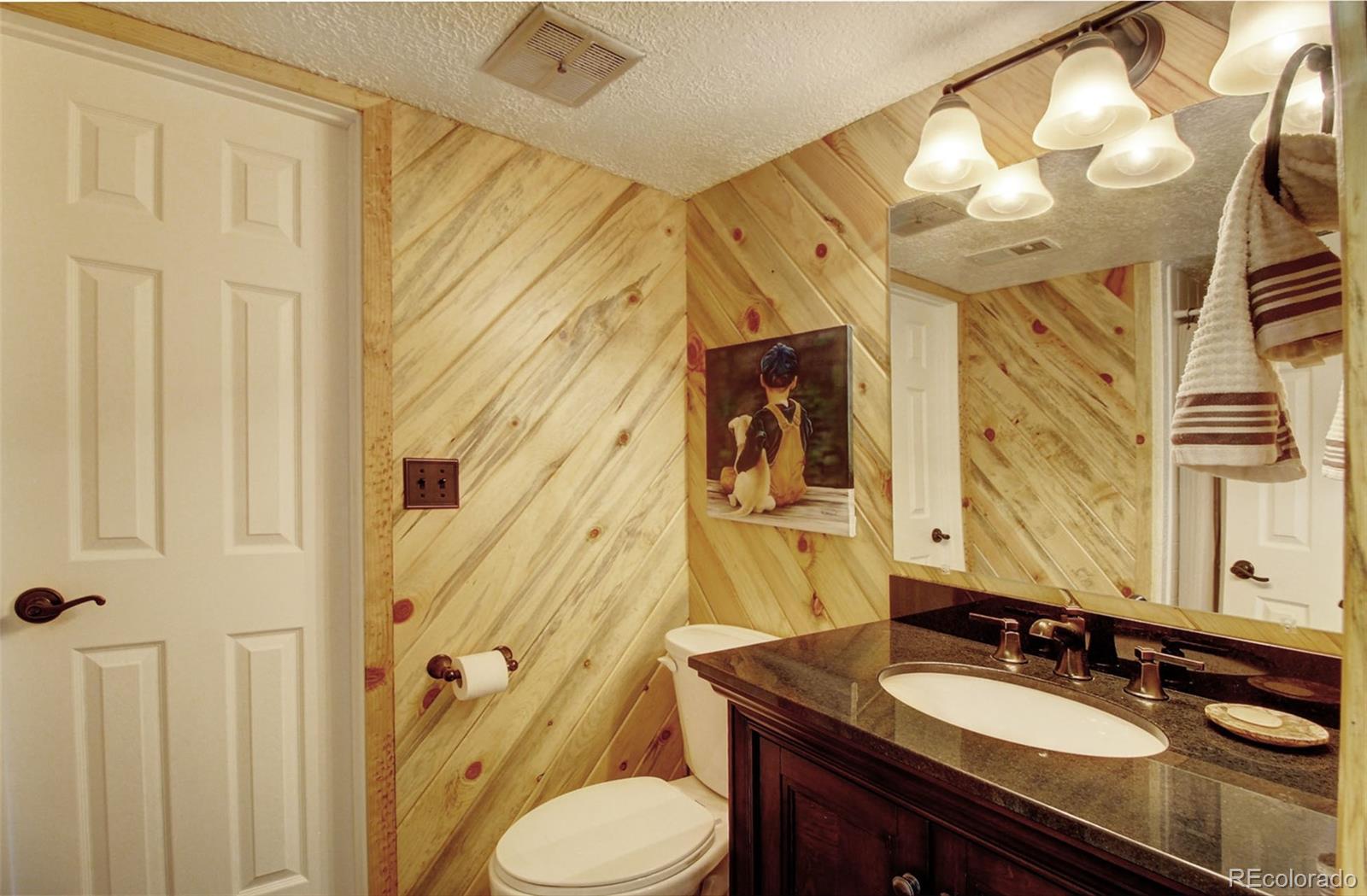 4345 Evans Road Monument, CO 80132 - Photo 36 of 40 a bathroom with a granite countertop sink toilet and shower