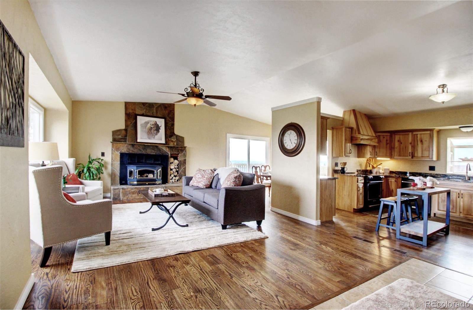 4345 Evans Road Monument, CO 80132 - Photo 6 of 40 a living room with furniture a fireplace and a large window