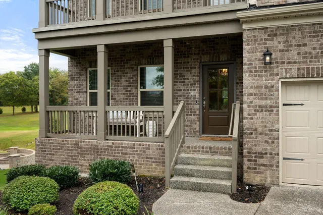 a view of a hallway with wooden floor and a chandelier