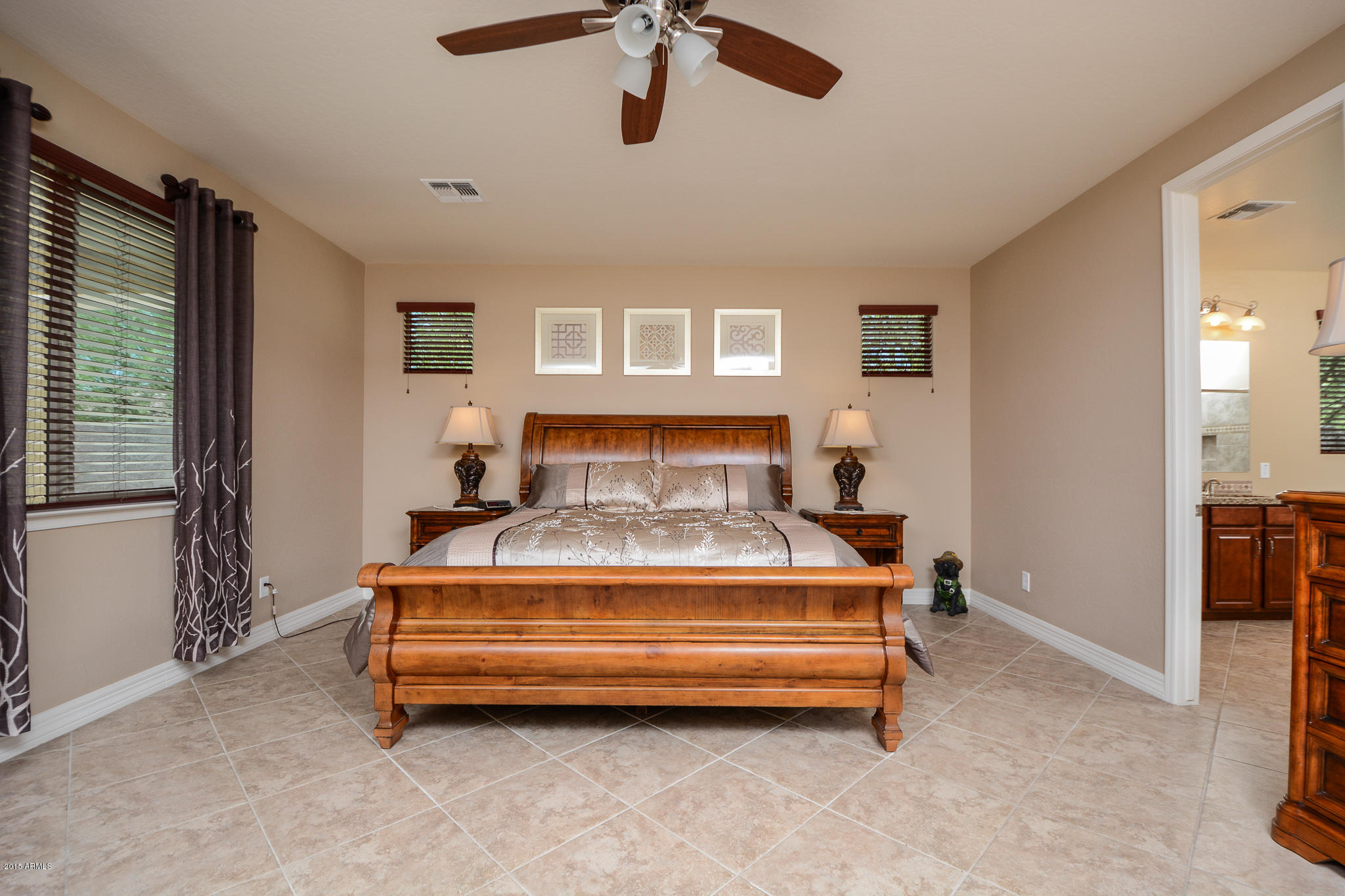 7545 West Redbird Road Peoria, AZ 85383 - Photo 11 of 23 a spacious bedroom with a bed and a chandelier