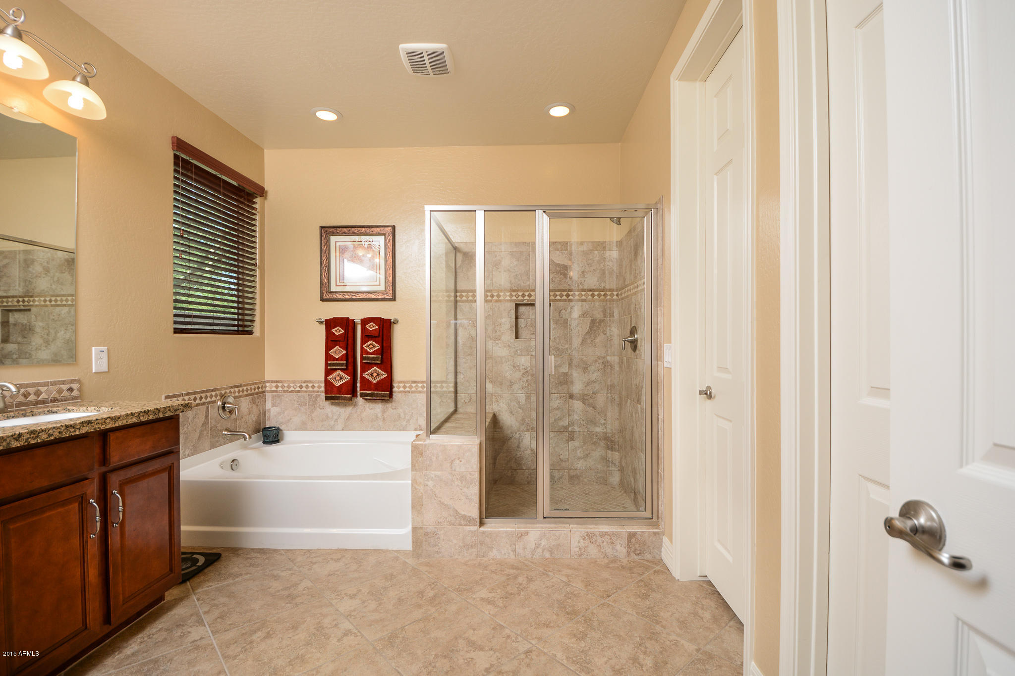 7545 West Redbird Road Peoria, AZ 85383 - Photo 12 of 23 a spacious bathroom with a bathtub sink and mirror