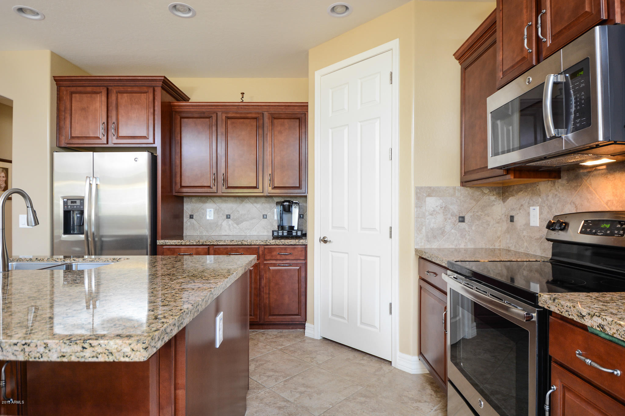 7545 West Redbird Road Peoria, AZ 85383 - Photo 5 of 23 a kitchen with stainless steel appliances granite countertop a sink stove and refrigerator