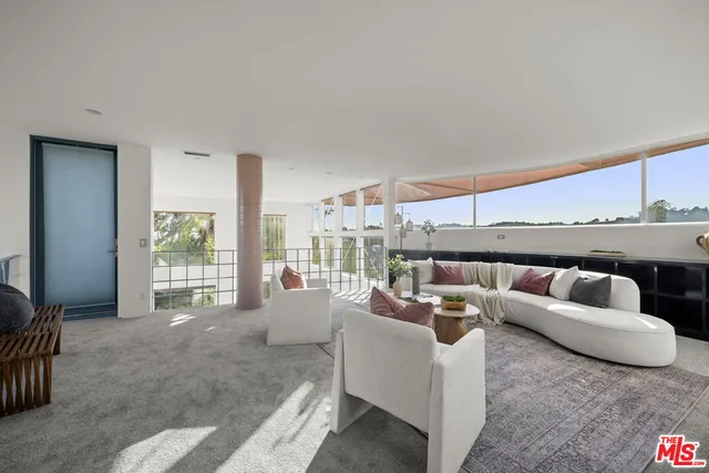 a living room with furniture a table and a large window