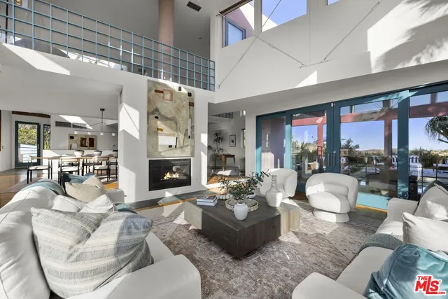 a living room with furniture large window and a fireplace