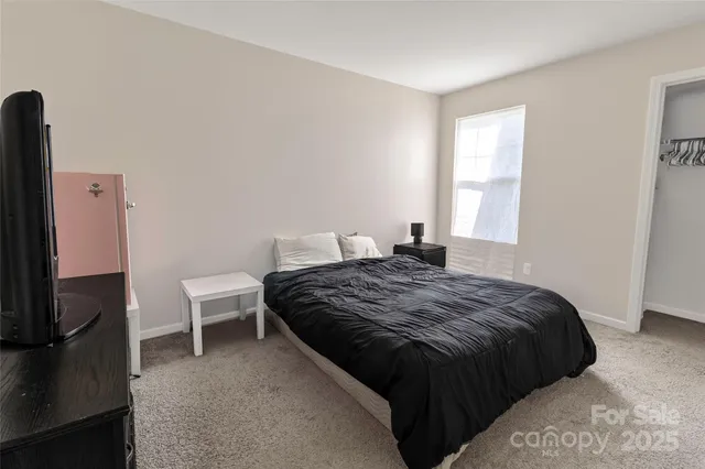 a bedroom with a bed and a tv on the dresser