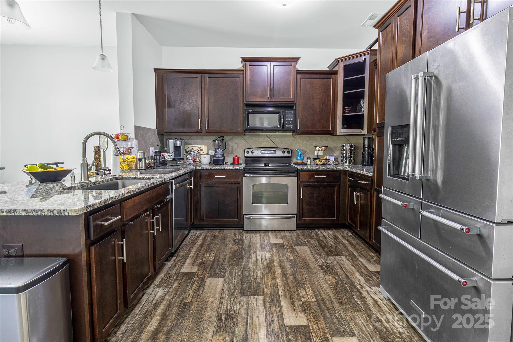 7017 Whitewater Loop Lowell, NC 28098 - Photo 4 of 24 a kitchen with stainless steel appliances granite countertop a sink stove refrigerator and cabinets
