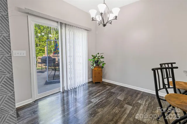 a view of a livingroom with wooden floor and a chandelier