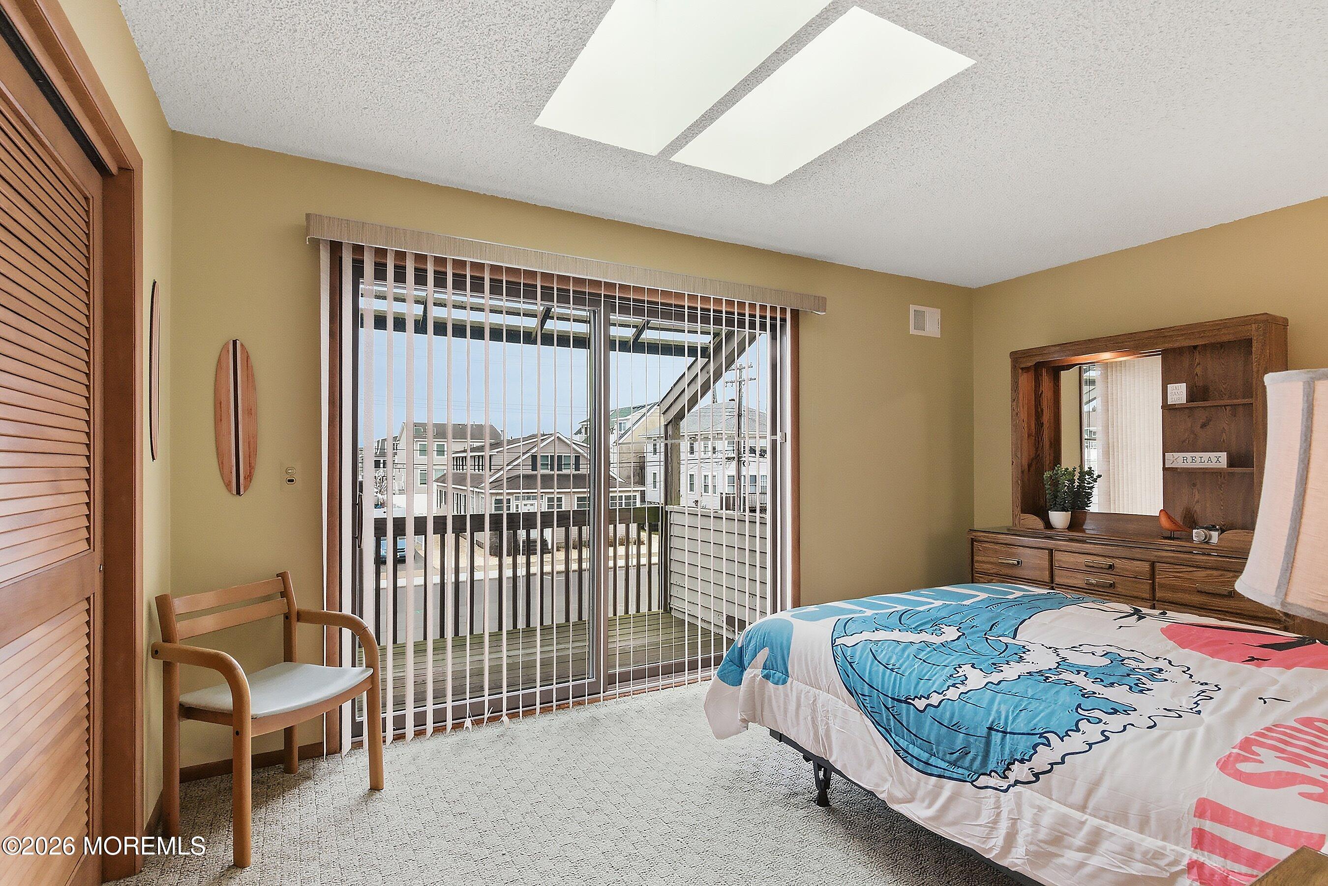 21 Brown Avenue, Unit 1 Lavallette, NJ 08735 - Photo 11 of 28 a bedroom with a bed and a large window