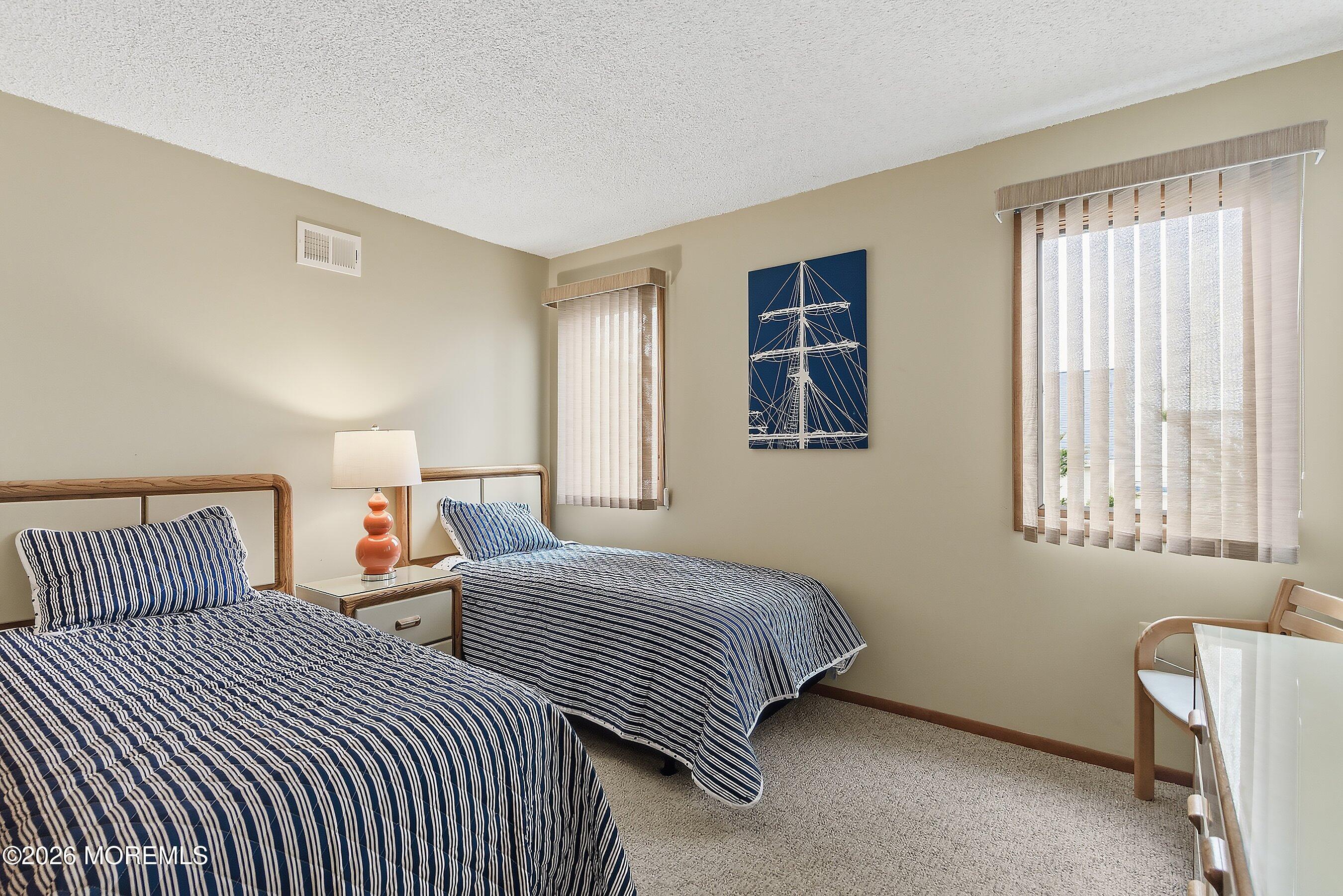 21 Brown Avenue, Unit 1 Lavallette, NJ 08735 - Photo 13 of 28 a bedroom with two beds and a window