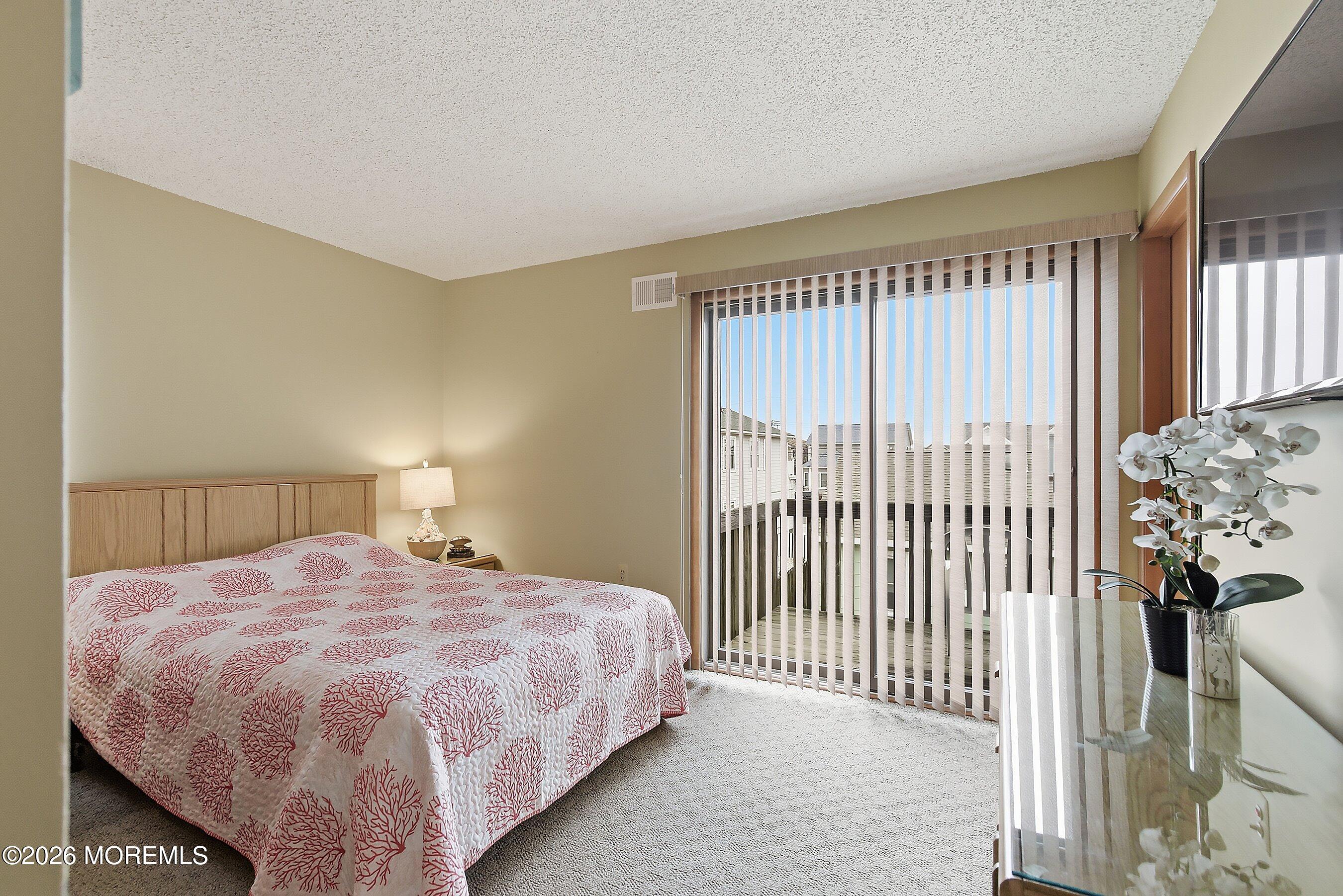 21 Brown Avenue, Unit 1 Lavallette, NJ 08735 - Photo 15 of 28 a bedroom with a bed and a window