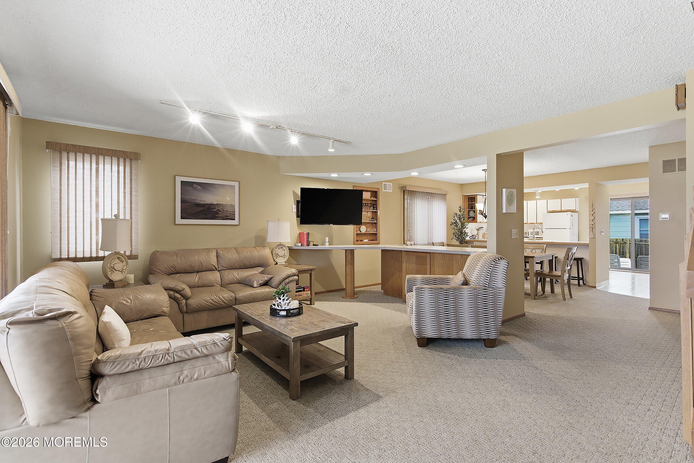 21 Brown Avenue, Unit 1 Lavallette, NJ 08735 - Photo 4 of 28 a living room with furniture and flat screen tv