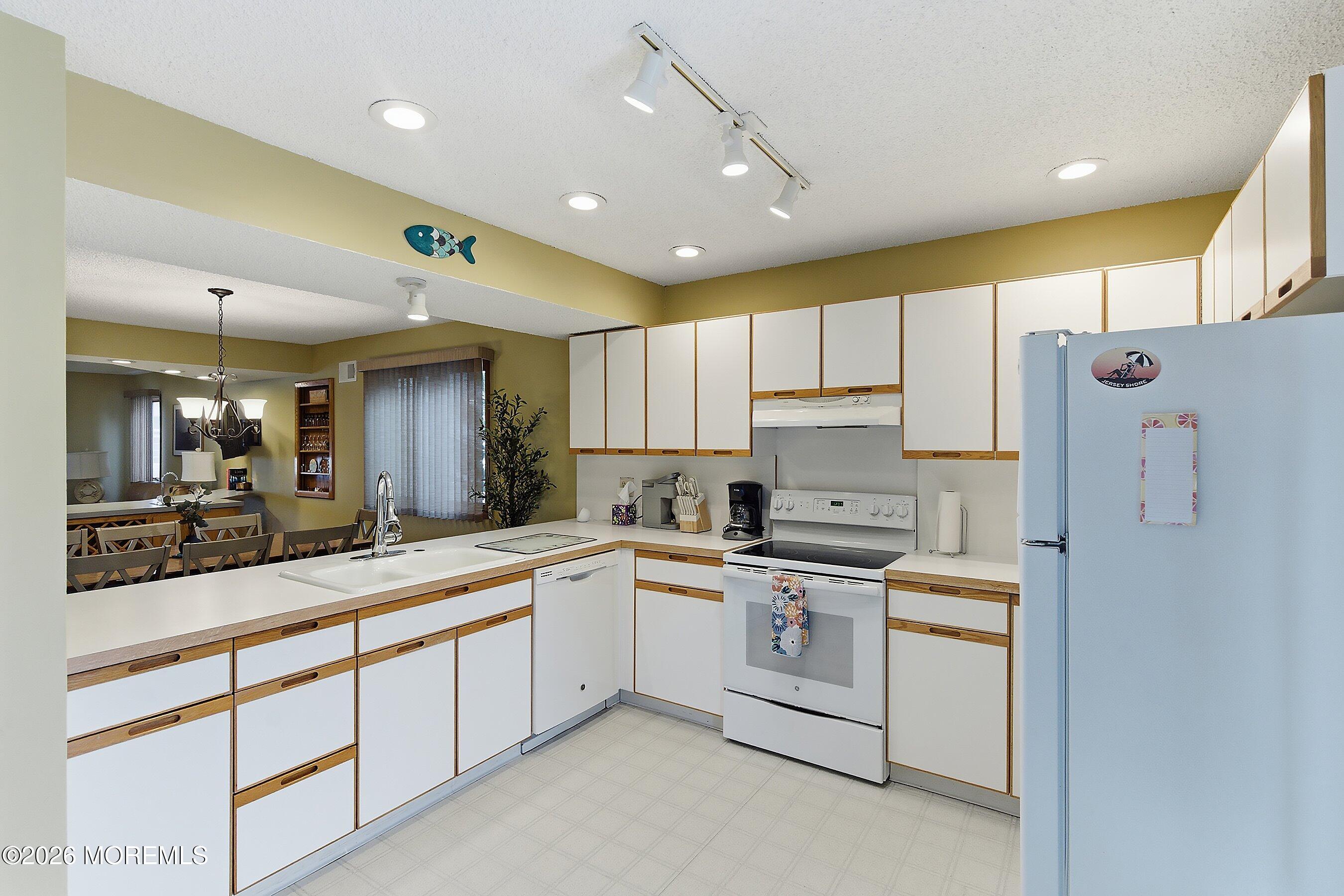 21 Brown Avenue, Unit 1 Lavallette, NJ 08735 - Photo 8 of 28 a kitchen with a sink a refrigerator and cabinets