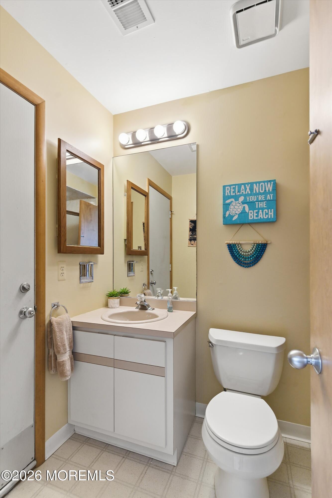 21 Brown Avenue, Unit 1 Lavallette, NJ 08735 - Photo 10 of 28 a bathroom with a toilet a sink and mirror