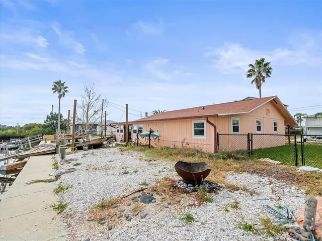 a view of a dry back yard with a tree
