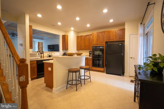 a kitchen with refrigerator and chairs