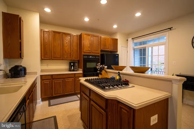 a kitchen with a stove a sink a refrigerator and cabinets