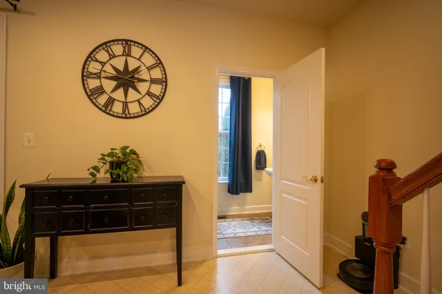a view of a hallway with wooden floor and a bathroom