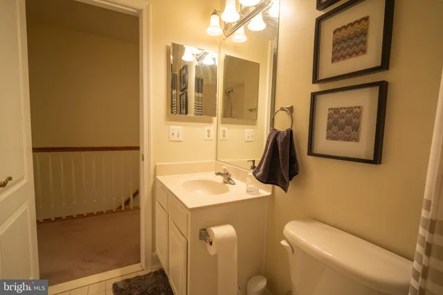 a bathroom with a sink and mirror with toilet