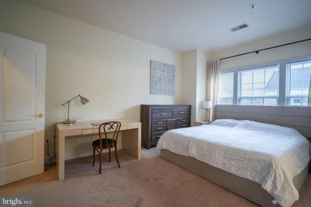 a bedroom with a bed a desk and chair