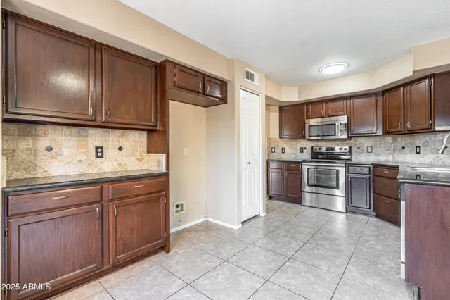 a kitchen with granite countertop stainless steel appliances and wooden cabinets