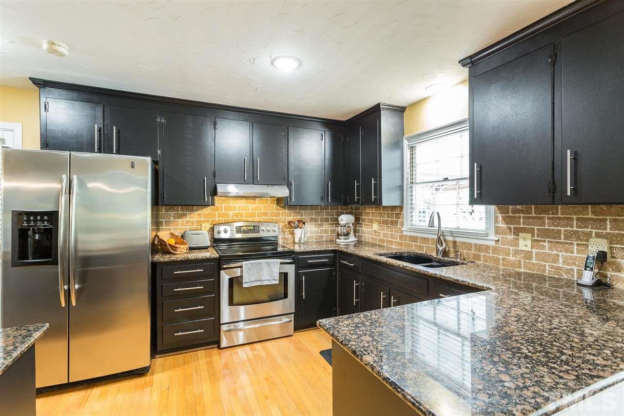 4300 Pike Road Raleigh, NC 27613 - Photo 17 of 28 a kitchen with stainless steel appliances granite countertop a sink stove and refrigerator