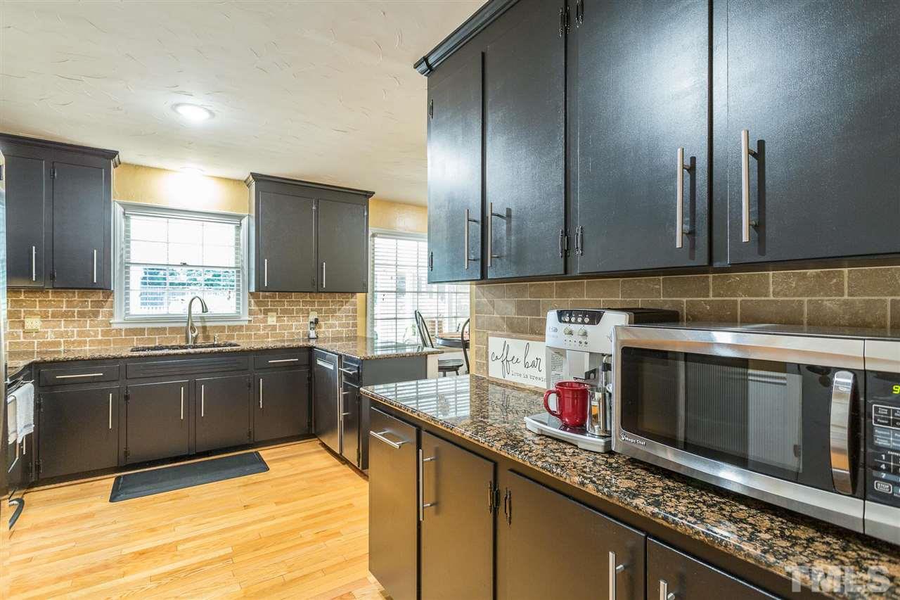 4300 Pike Road Raleigh, NC 27613 - Photo 21 of 28 a kitchen with stainless steel appliances granite countertop a sink stove and microwave