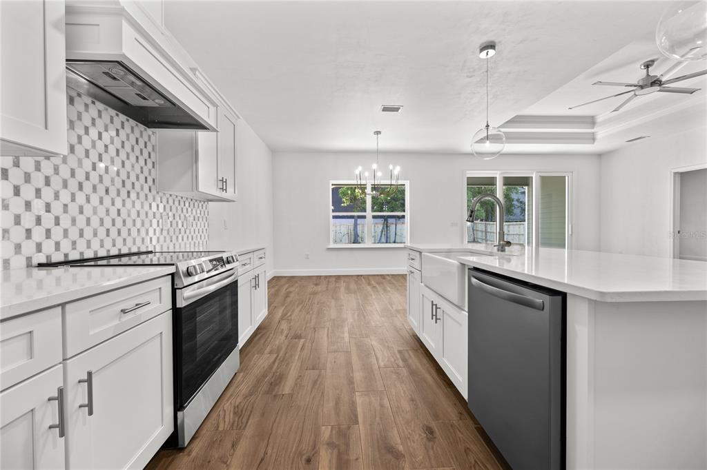 1086 Southwest 67th Drive Gainesville, FL 32607 - Photo 20 of 37 a large kitchen with cabinets wooden floor and stainless steel appliances