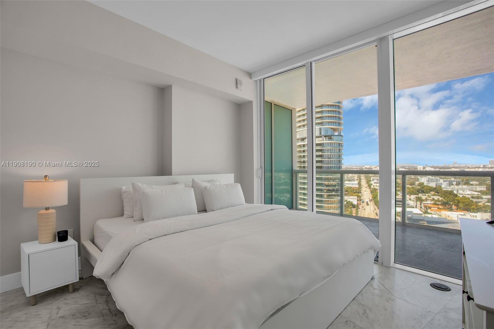 450 Alton Road, Unit 2110 Miami Beach, FL 33139 - Photo 12 of 33 a bedroom with a large bed and a large window