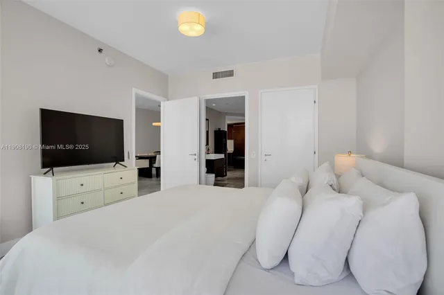 a bedroom with a bed and a flat screen tv