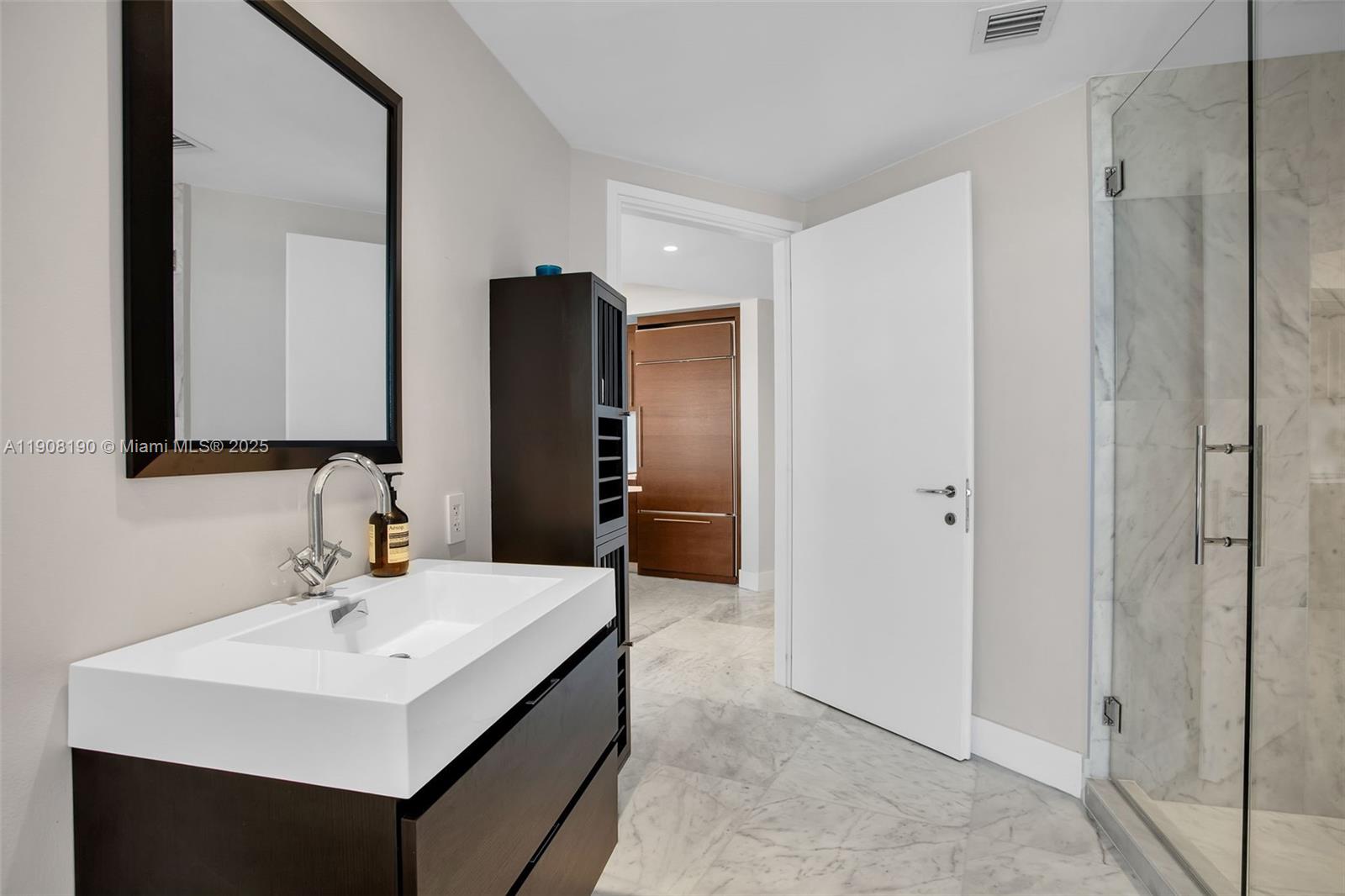 450 Alton Road, Unit 2110 Miami Beach, FL 33139 - Photo 15 of 33 a bathroom with a sink a toilet and a mirror