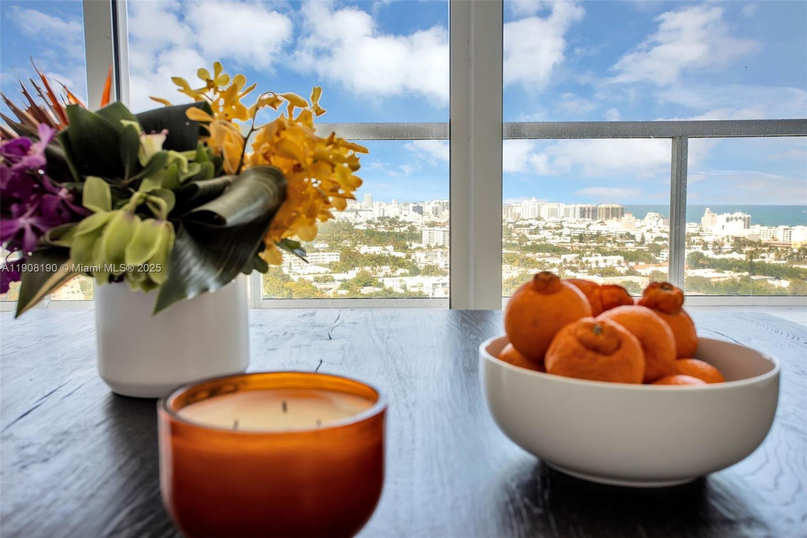 450 Alton Road, Unit 2110 Miami Beach, FL 33139 - Photo 3 of 33 a table with chairs and a vase with flowers